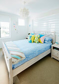 Doppelbett mit bunten Kissen in hellem Gästezimmer
