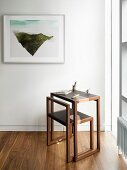 Elegant minimalist desk and chair next to window and framed modern artwork on wall