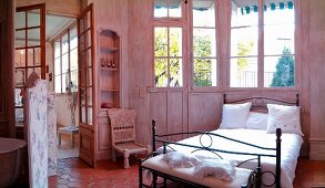 Schlafzimmer im französischen Stil mit Metallbett und Sprossenfenstern