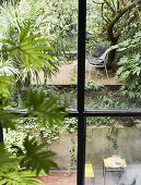 View through window into back courtyard garden on two levels