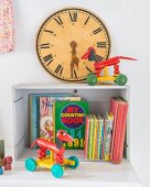 Vintage toy clock with Roman numerals, retro toys and colourful children's books