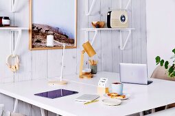 White desks and wall brackets on plank wall