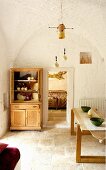 Wooden table and dresser against whitewashed walls in renovated trullo
