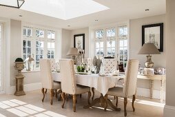 Period furniture and skylights in elegant living room in shades of cream