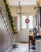 Weihnachtlich geschmückter Hauseingang mit Girlande am Geländer