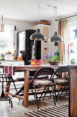 Folding metal chairs around wooden table in country-house kitchen
