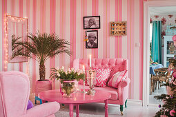 Striped wallpaper in kitsch living room decorated entirely in pink and hot pink