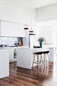 Moderne weiße Küche mit glänzendem Holzboden
