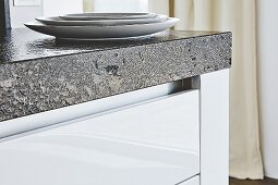 A granite worktop over white kitchen drawers