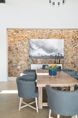 Eleganter Essbereich mit Designerstühlen und steinverkleideter Wand