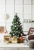Leather armchairs and gifts around the Christmas tree in front of a cassette wall