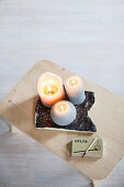 Brennende Kerzen und Streichholzschachtel auf einem Hocker