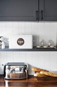 Shelf below wall-mounted cupboards in grey and white country-house kitchen