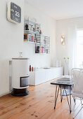 Small cylindrical stove and designer shelves in white living room
