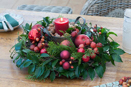 Red candle made of Ilex and conifers branches