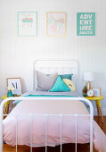 Metallbett im pastellfarben dekorierten Schlafzimmer