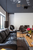 Black leather sofa in vintage living room with painted ceiling