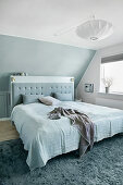 Blue and white bedroom with sloping ceiling