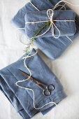 Gifts wrapped in blue fabric tied with parcel string