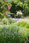 Meadow flowers and romantic seating area in summer garden