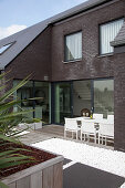 Dining area on roof terrace of modern brick house