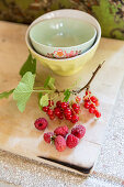 Sprig of redcurrants and raspberries on wooden board