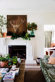 Deer picture and branches on a fireplace console in the living room