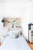 Pinboard on white wall above bed in child's bedroom