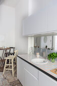 White kitchen counter and bistro table with barstools