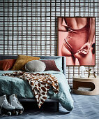 Doppelbett vor Wand mit Tapete und großformatigem Foto, daneben runder Nachttisch