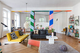 Colourful partition with wide stripes and lounge area in open-plan interior