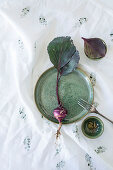 Bowls, plate and purple kohlrabi on printed cloth
