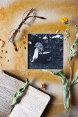 Schwarz-weißes Foto in DIY-Passepartout, Trockenblume, Notizbuch und Brille