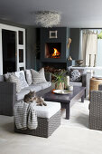 Lounge furniture and fitted fireplace on roofed terrace in shades of grey