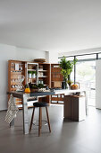 Stainless steel island counter and trunk-style folding cabinet in kitchen