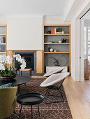 Classic chairs and coffee table with orchid in front of built-in fireplace and open wooden shelf
