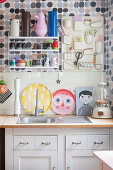 Colourful utensils in kitchen with polka-dot wallpaper