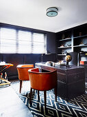 Leather chairs and antique leather desk in the study with dark wall shelf and leather wall covering