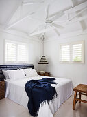 Doppelbett und Deckenventilator im Schlafzimmer mit weißem Dachkonstruktion aus Holz
