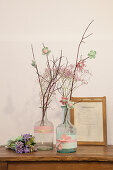 Fabric flowers on twigs in bottles decorated with fabric trim