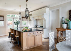 Barstools at large island counter in open-plan kitchen