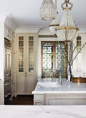 Antique chandelier over kitchen island with marble countertop