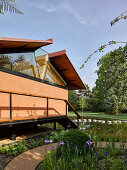 Modernes Haus mit offenem Dach im sommerlichen Park