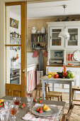 View over set dining table into cosy country-house kitchen