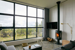 Wohnzimmer mit Blick durch Panoramafenster in die Landschaft