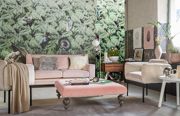 Furniture with pink and beige upholstery against jungle-patterned wallpaper