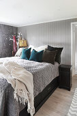 Bedroom in wintry shades with grey wooden cladding on walls