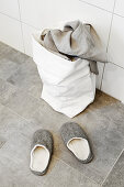 Slippers and laundry bag in bathroom