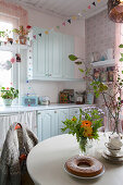Cosy kitchen-dining room with pale blue country-house-style cabinets