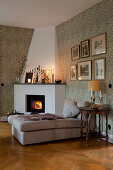 Chaise in front of fire in corner fireplace